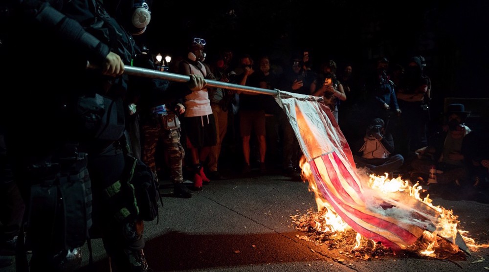 Police deployed in Portland as protesters burn US flag