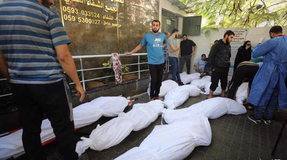 Palestinians dig mass grave as bodies pile up inside Israeli-encircled Gaza hospital