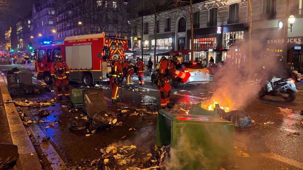 French police fire tear gas as protesters set piles of rubbish on fire in Paris