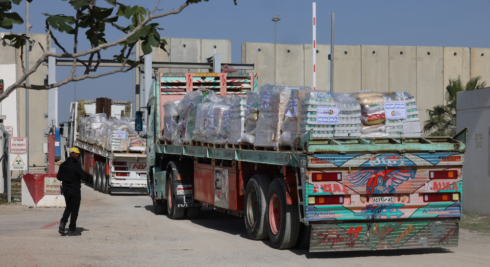 Gazans rush towards aid trucks carrying flour and canned food in Gaza City