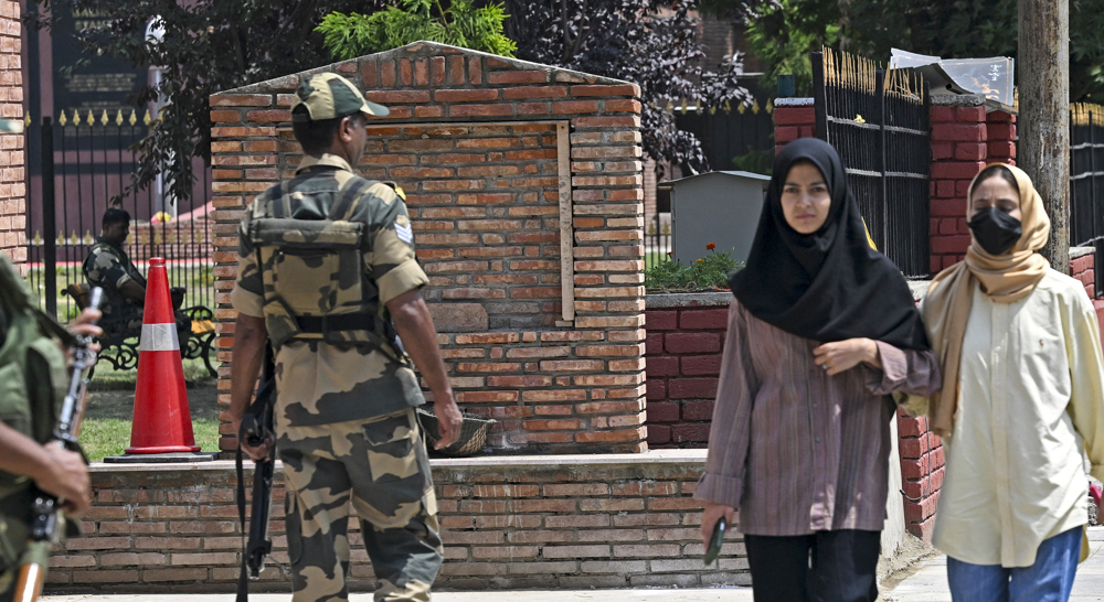 Indian Border Security Force (BSF) soldiers stand guard along a street in Srinagar on August 16, 202