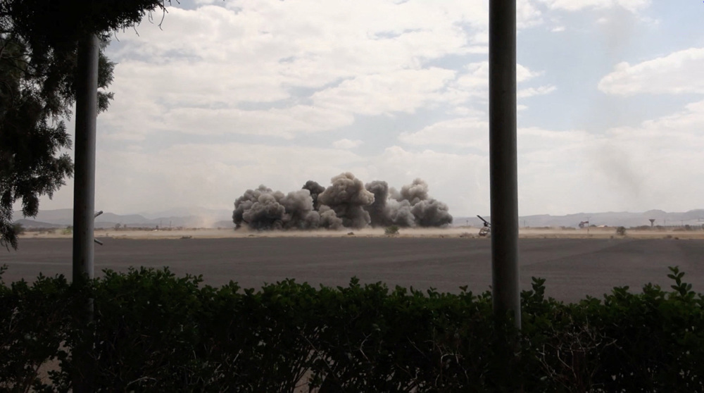 This image taken from video broadcast by Yemen’s al-Masirah TV shows an explosion at the Sana’a Inte