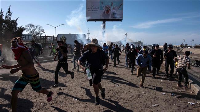 Tear gas fired on migrants near Mexico border fence
