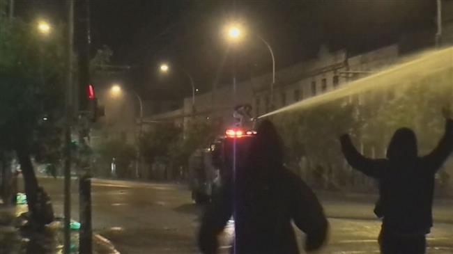 Protester disables water cannon in Chile