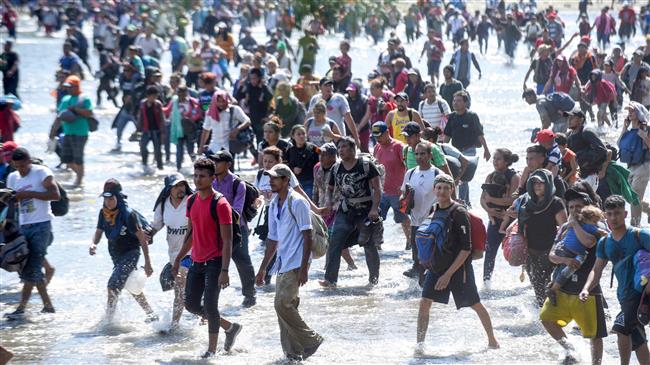 Clashes as caravan migrants cross river into Mexico