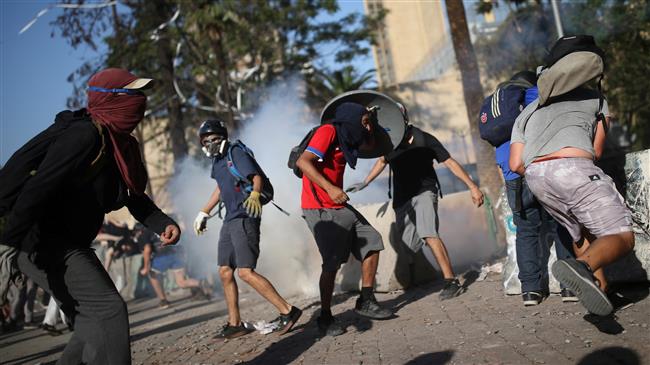 Tear gas, rocks fly in Chile as protesters face off with police