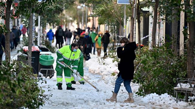 Residents join police in clean-up efforts after snowfall in Madrid